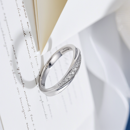 Silver ring with small diamonds on a piece of paper