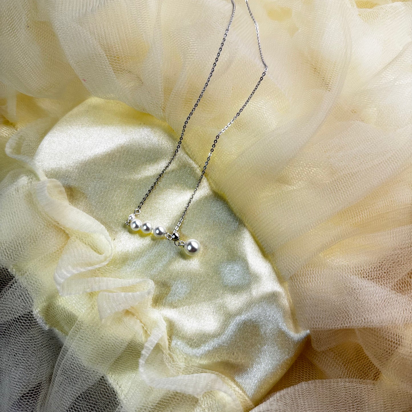 Necklace with small beads on a light yellow fabric background