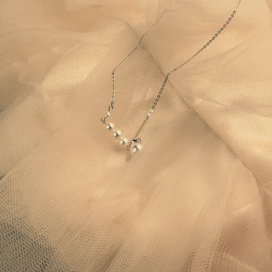 Pearl necklace on a beige fabric background